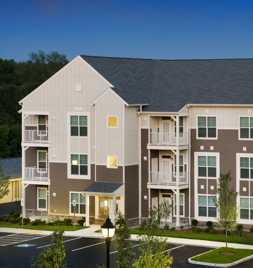3-story brown and tan paneled apartment building