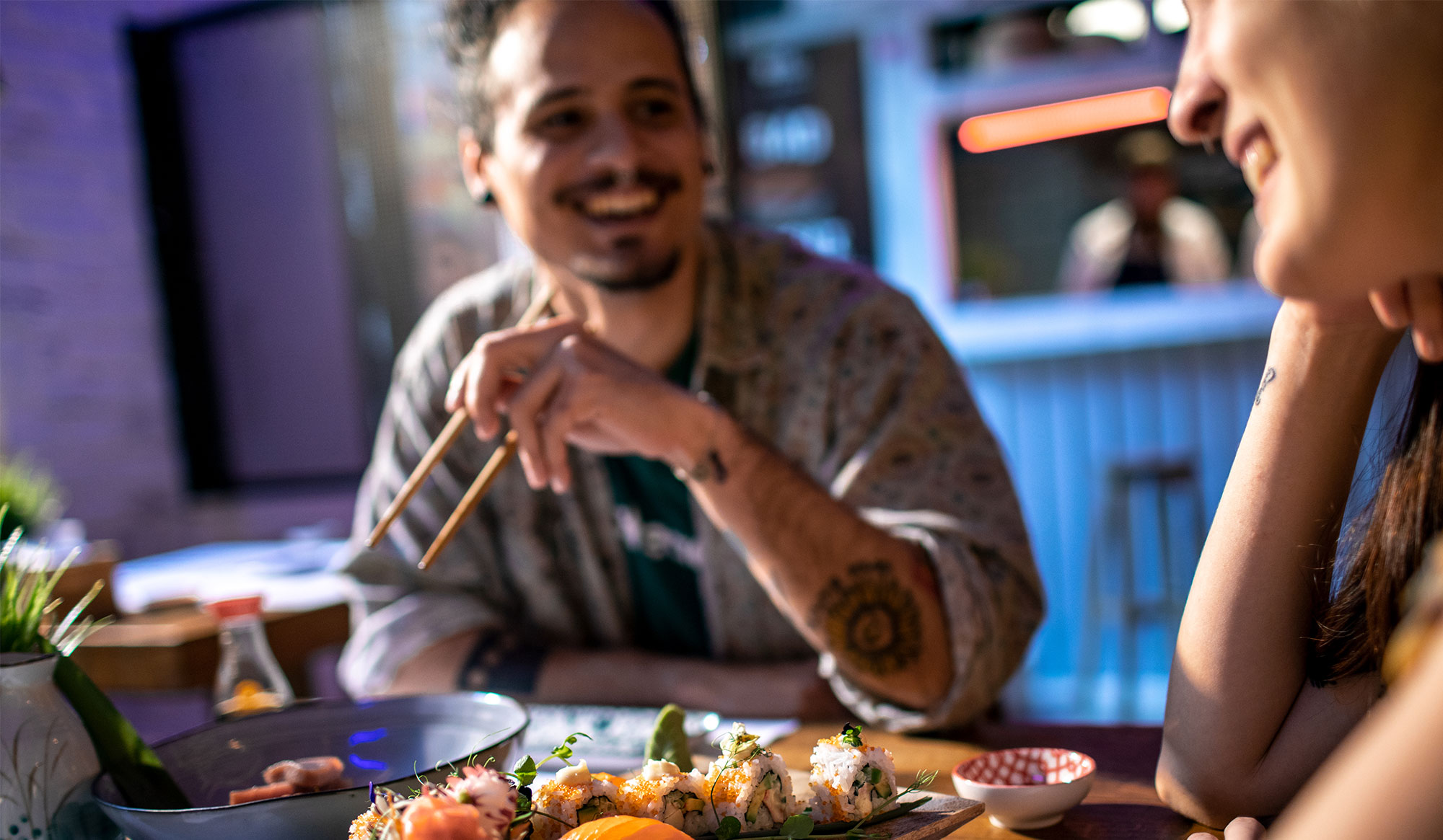 2 friends laugh together over sushi 