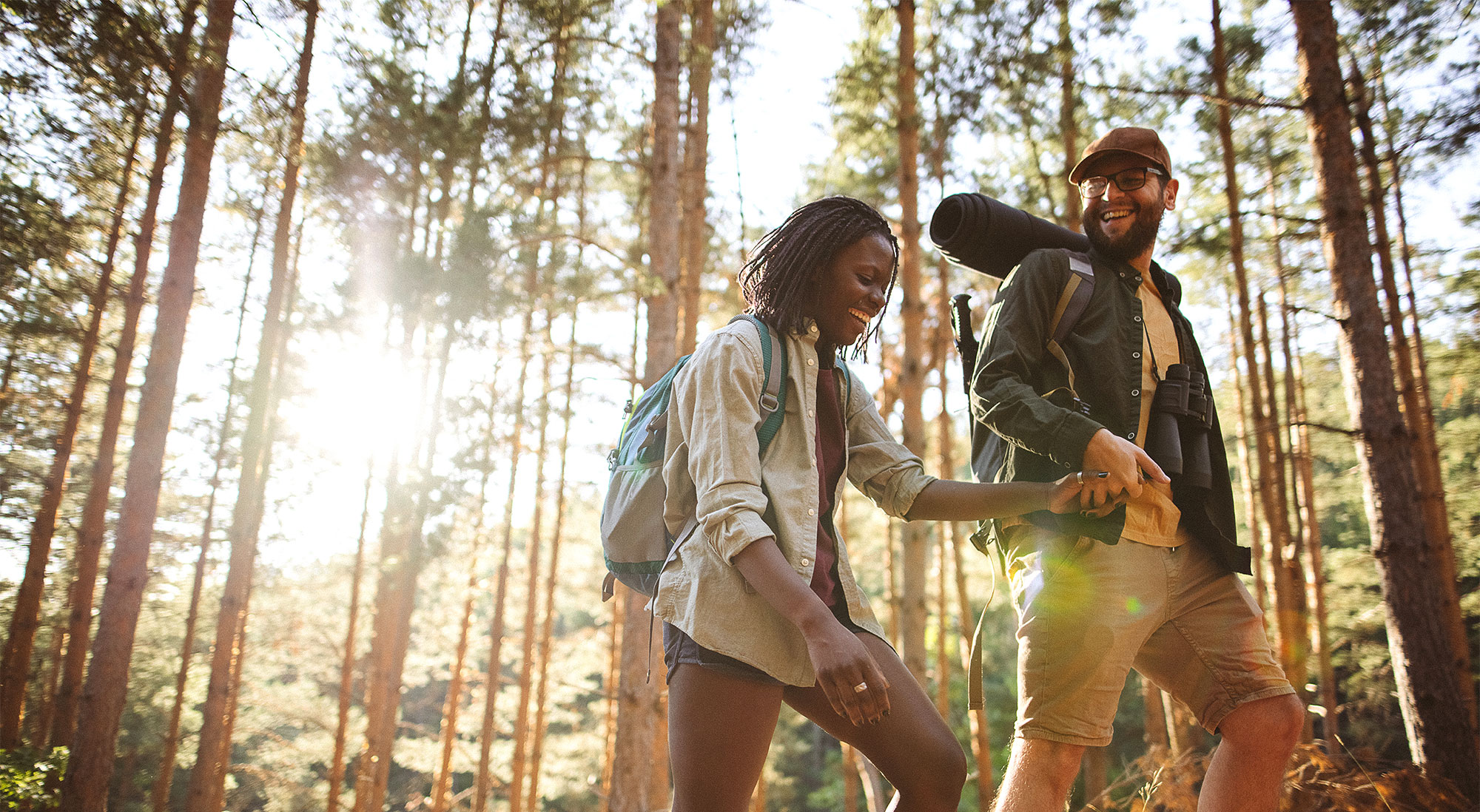 A couple holds hands while hiking together 