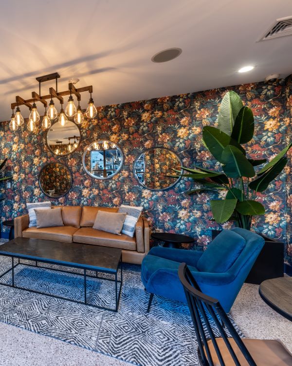 Three friends laugh around a grill on a summer afternoon